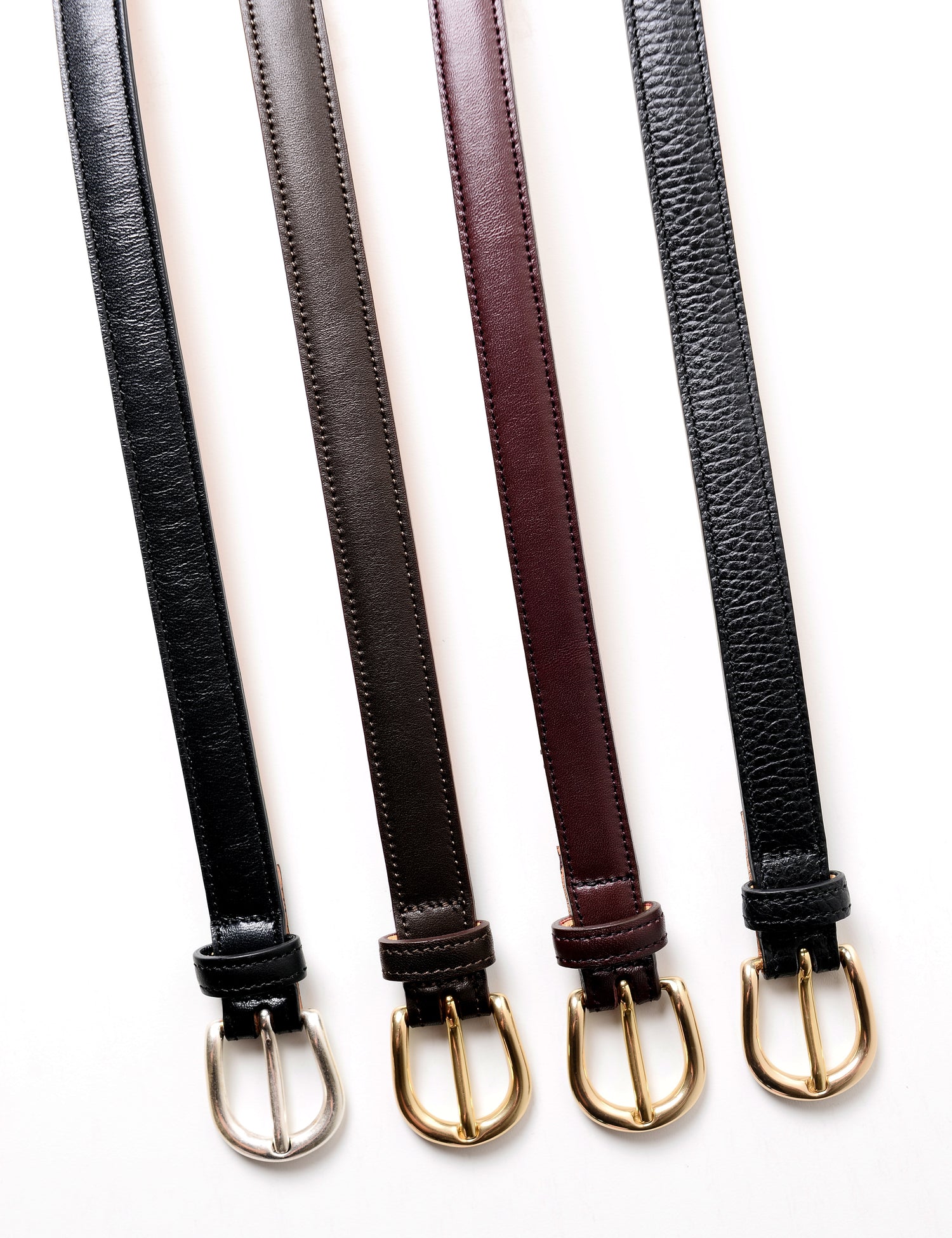 Close-up flat shot of all four styles of the Brooklyn Tailors x Saddler's 20mm belts showing the different colors, leather grains, and buckles