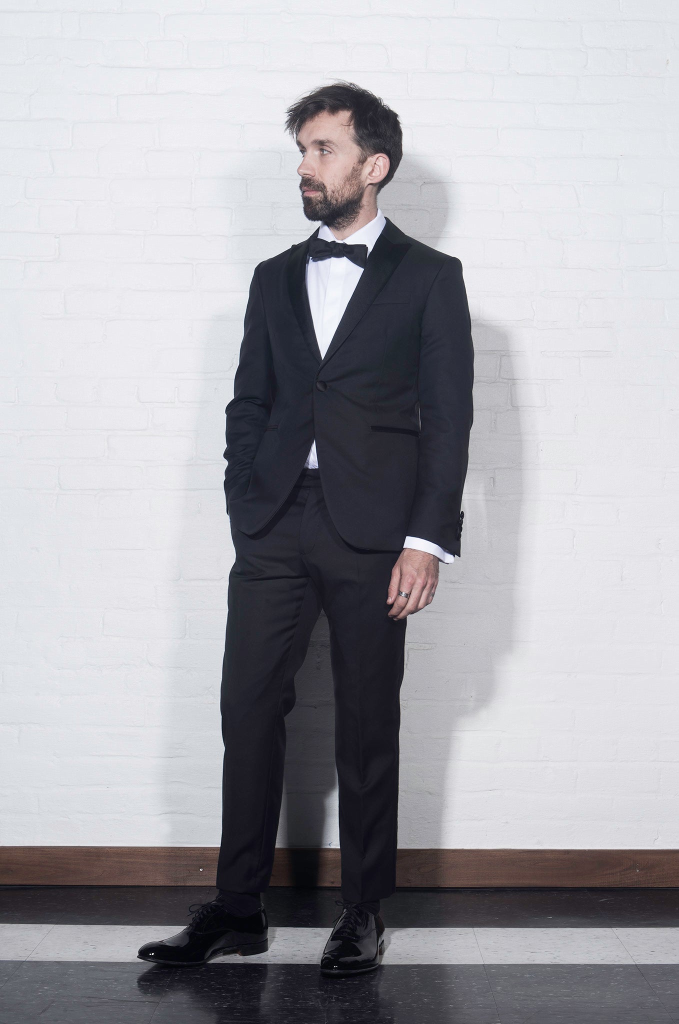 Brooklyn Tailors BKT50 Peak Lapel Tuxedo Jacket in Super 110s - Black with Satin Lapel on-body shot. Side-view of the jacket with matching pants