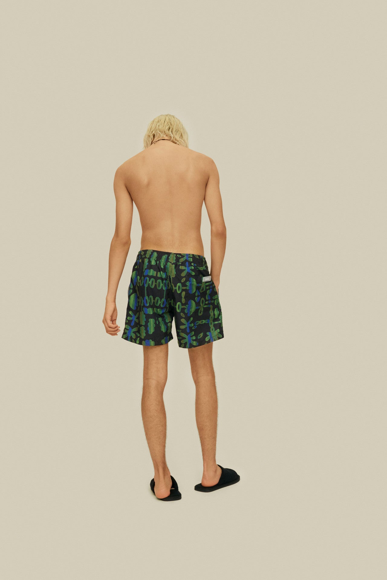 On-body back side photo of OAS Feral Galbanum Swim Shorts