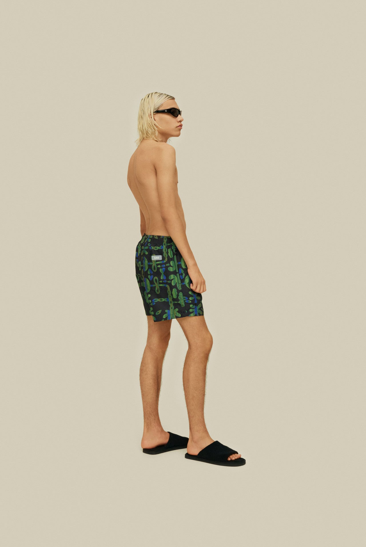 On-body side-facing photo of OAS Feral Galbanum Swim Shorts