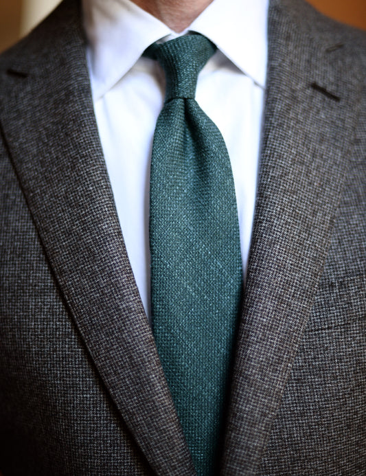 Silk, Wool, and Linen Hopsack Tie - Emerald on body. Model is wearing a suit jacket and white dress shirt. 