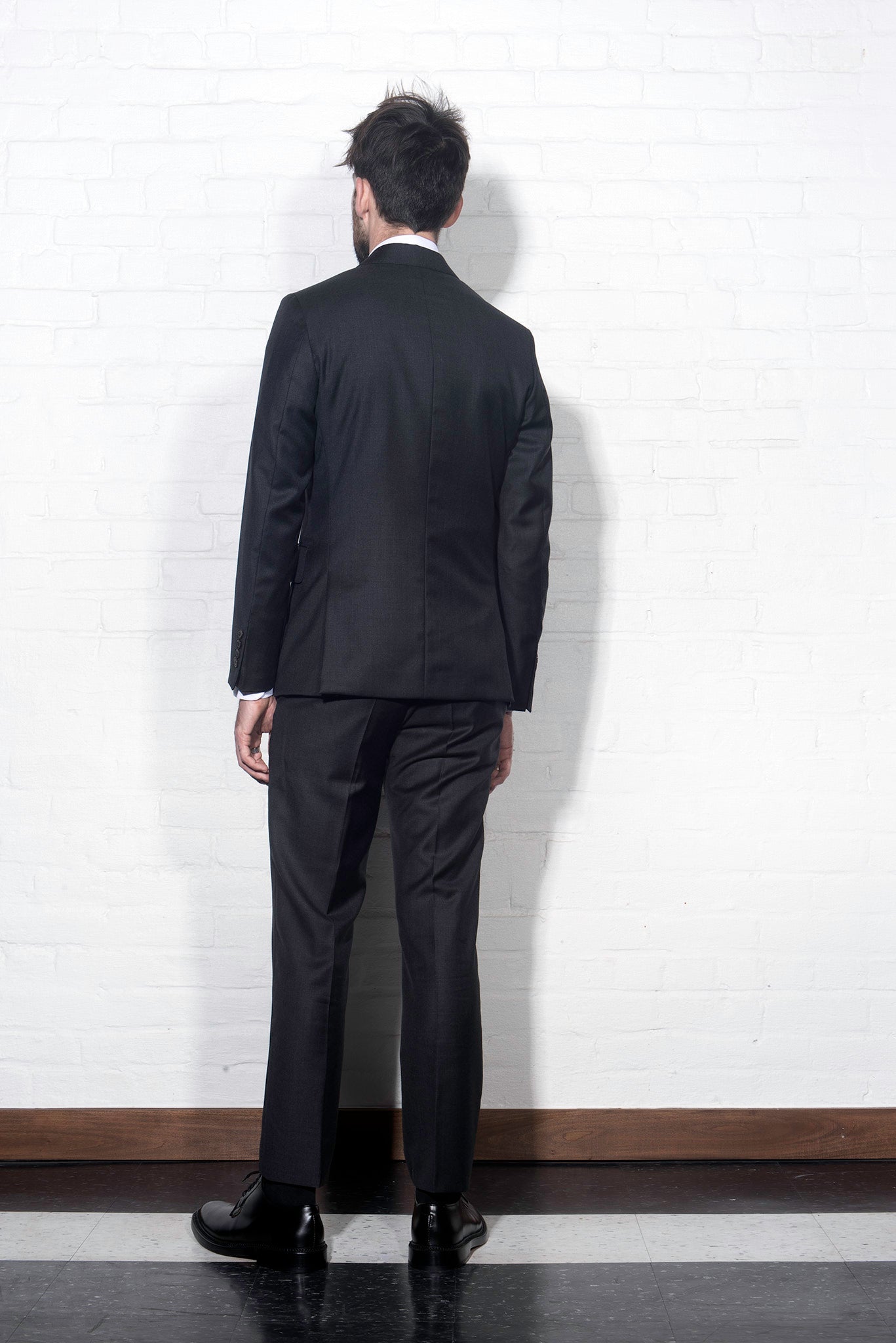 Brooklyn Tailors BKT50 Tailored Jacket in Super 110s Twill - Charcoal on-body shot from the back. Model is wearing the jacket with matching pants, a white dress shirt and tie.