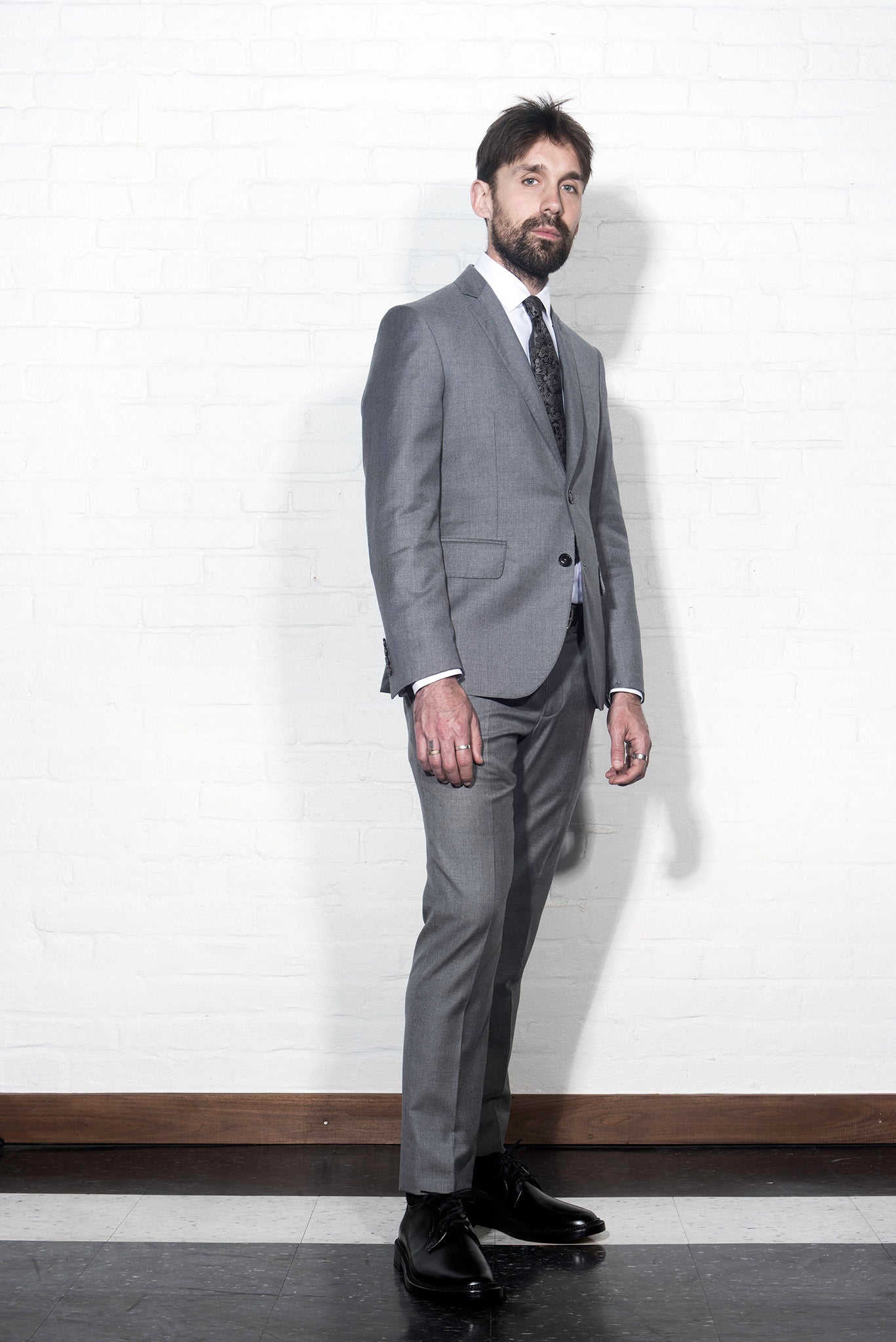 Brooklyn Tailors BKT50 Tailored Trouser in Super 110s Twill - Dove Gray on-body shot. Model is wearing pant with matching jacket, white dress shirt, and tie. Photo taken from side