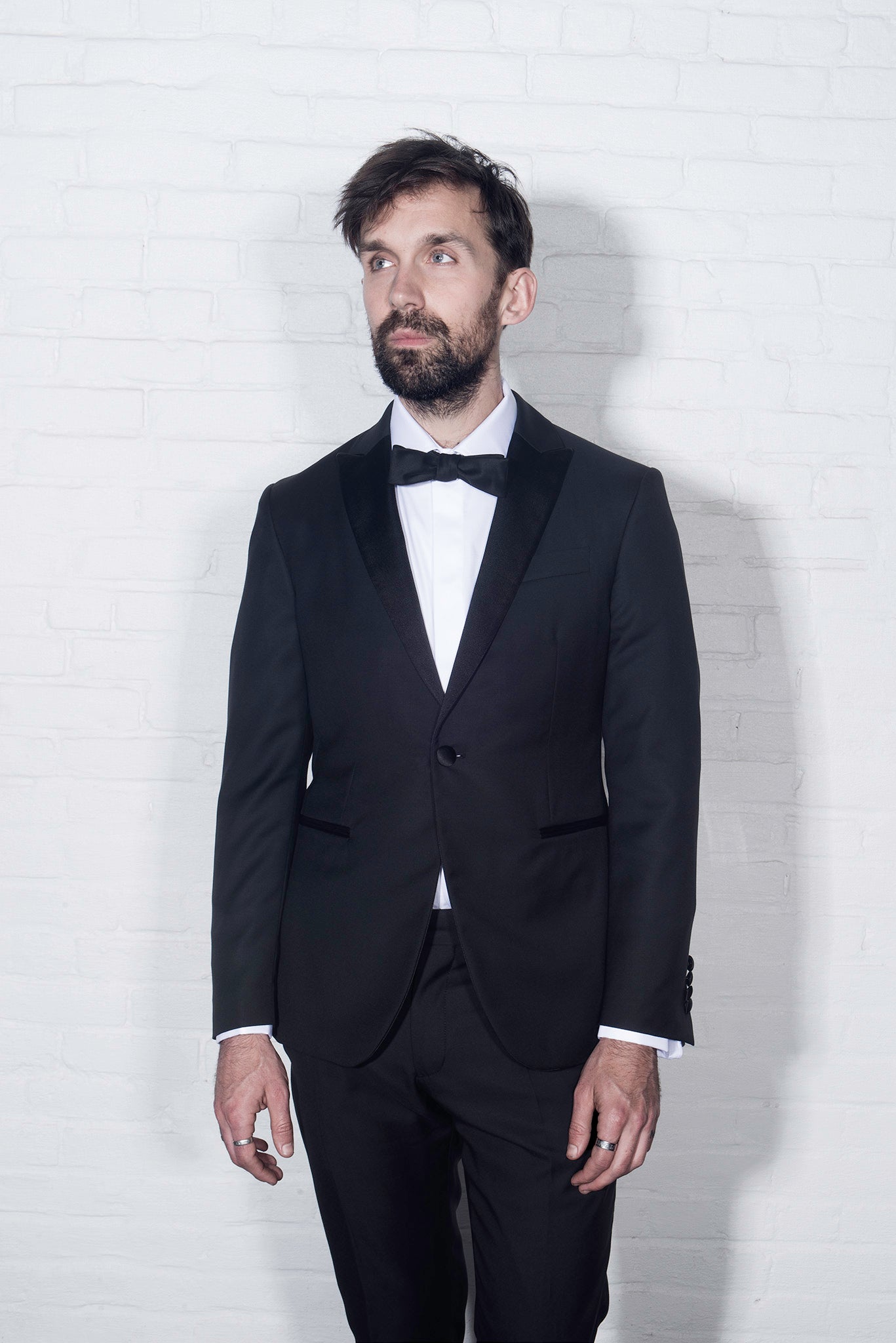 On-body shot of Brooklyn Tailors BKT50 Tuxedo Trouser in Super 110s - Black with Satin Stripe. Model is wearing tuxedo trouser with matching jacket, white tuxedo shirt, and black bowtie