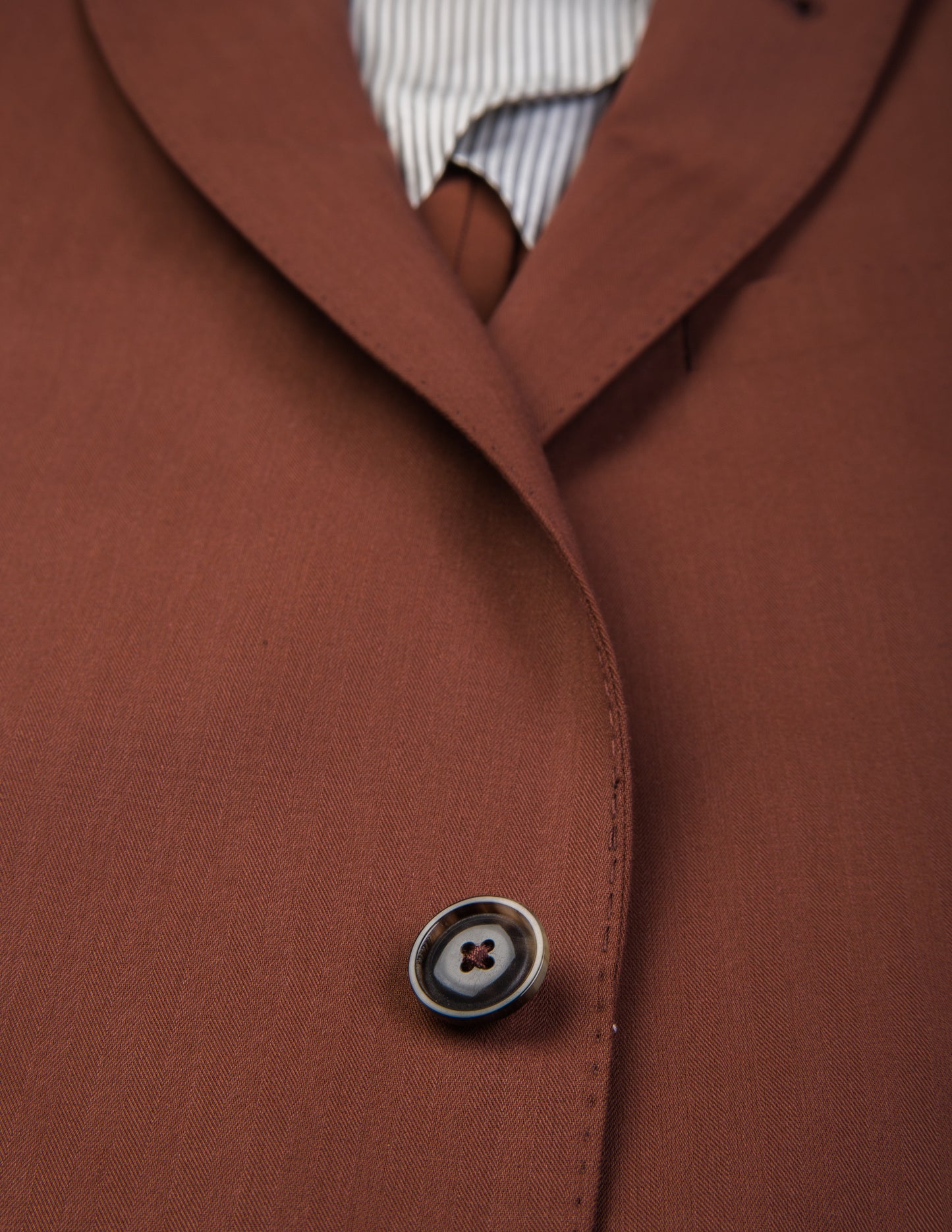Detail shot of Brooklyn Tailors BKT50 Tailored Jacket in Herringbone Wool/Cotton - Brick showing button and fabric texture
