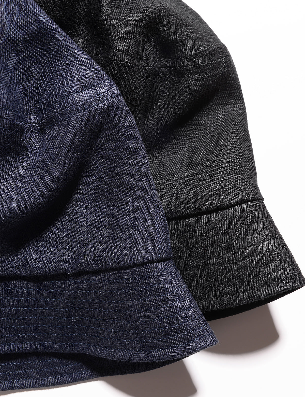 Detail of two Cableami French Linen Bucket Hats showing fabric weave