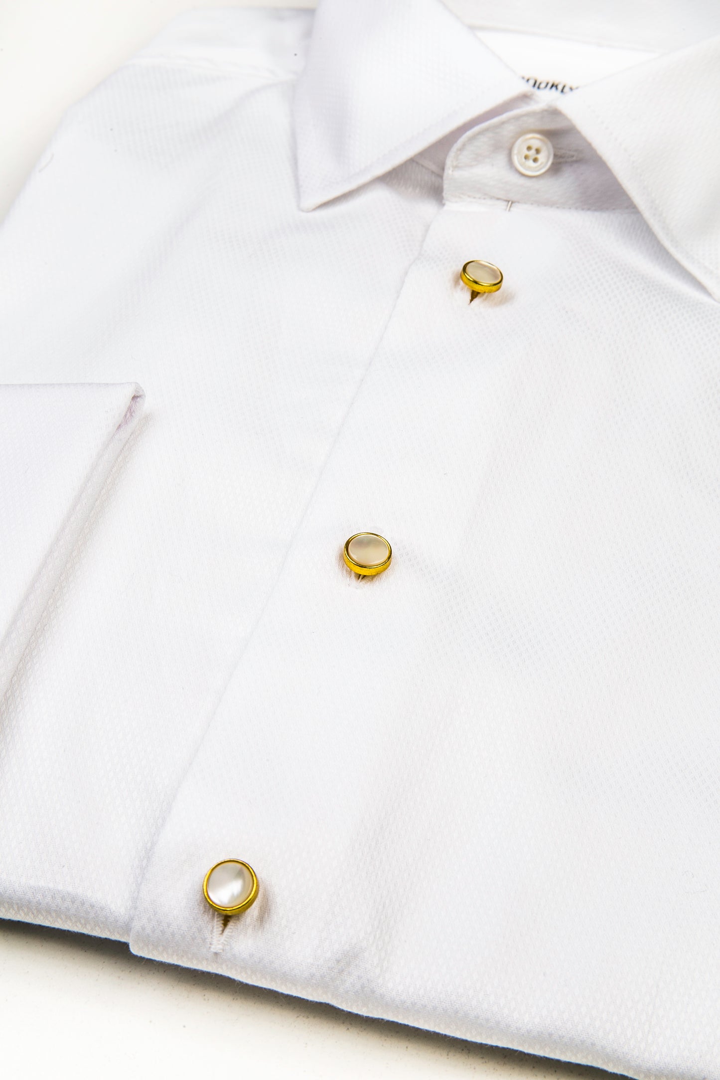 Detail of Mother of Pearl & Brass Dress Studs in a tuxedo shirt