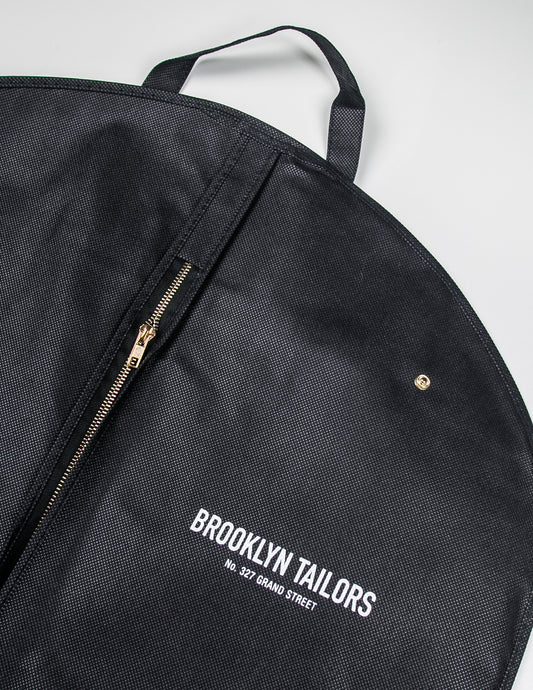 Detail shot of BROOKLYN TAILORS - Garment Bag showing zipper, logo, snap, and handle