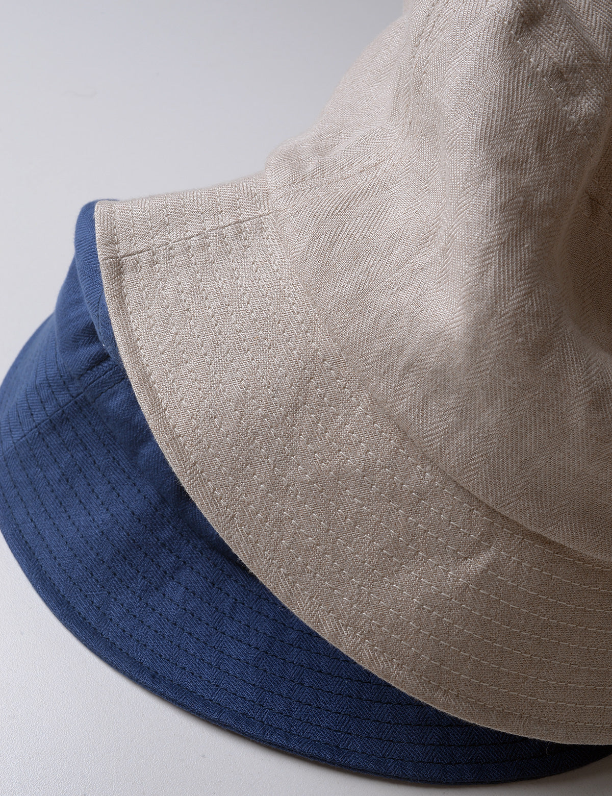 Detail of two Cableami French Linen Bucket Hats showing fabric weave