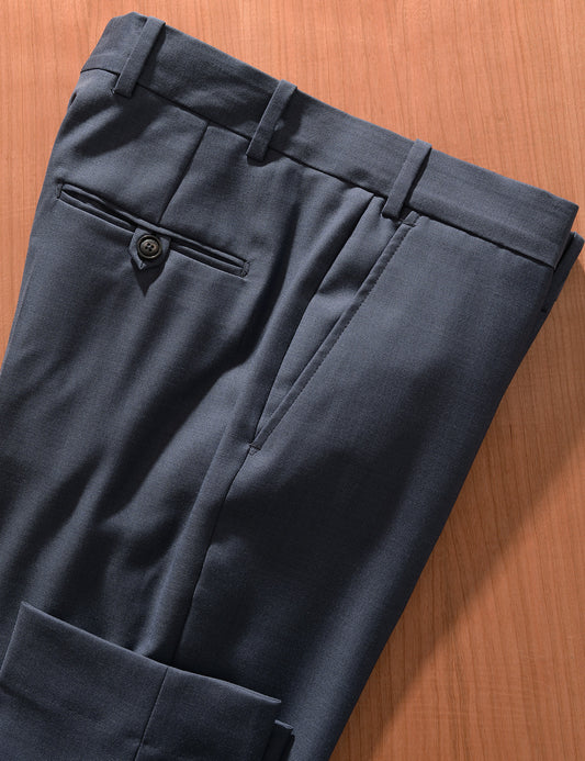 Detail of BKT50 Tailored Trousers in Wool Sharkskin - Haze Blue showing hem, back pocket, and fabric texture