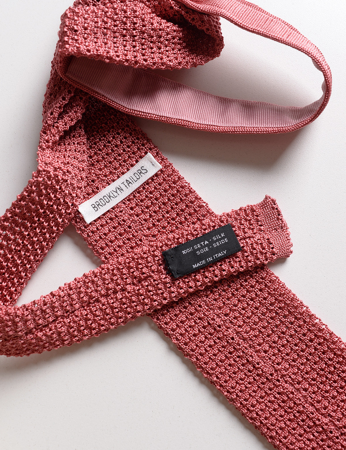 Detail of labels and knit of Brooklyn Tailors Italian Silk Knit Tie - Coral