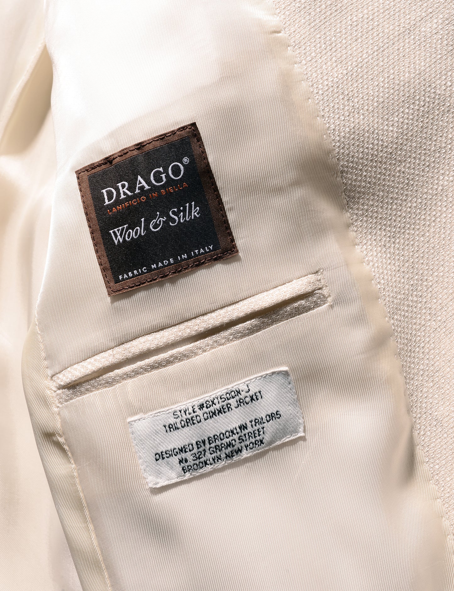 Detail shot of Brooklyn tailors BKT50 Shawl Collar Dinner Jacket in Silk & Wool Textured Weave - Ivory showing Drago label on interior panel of jacket