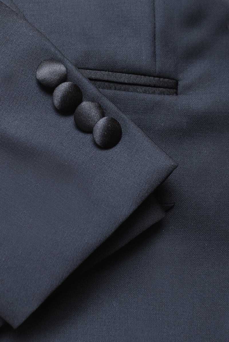 Detail shot of Brooklyn Tailors BKT50 Peak Lapel Tuxedo Jacket in Super 110s - Black with Satin Lapel showing cuff, covered buttons, and pocket