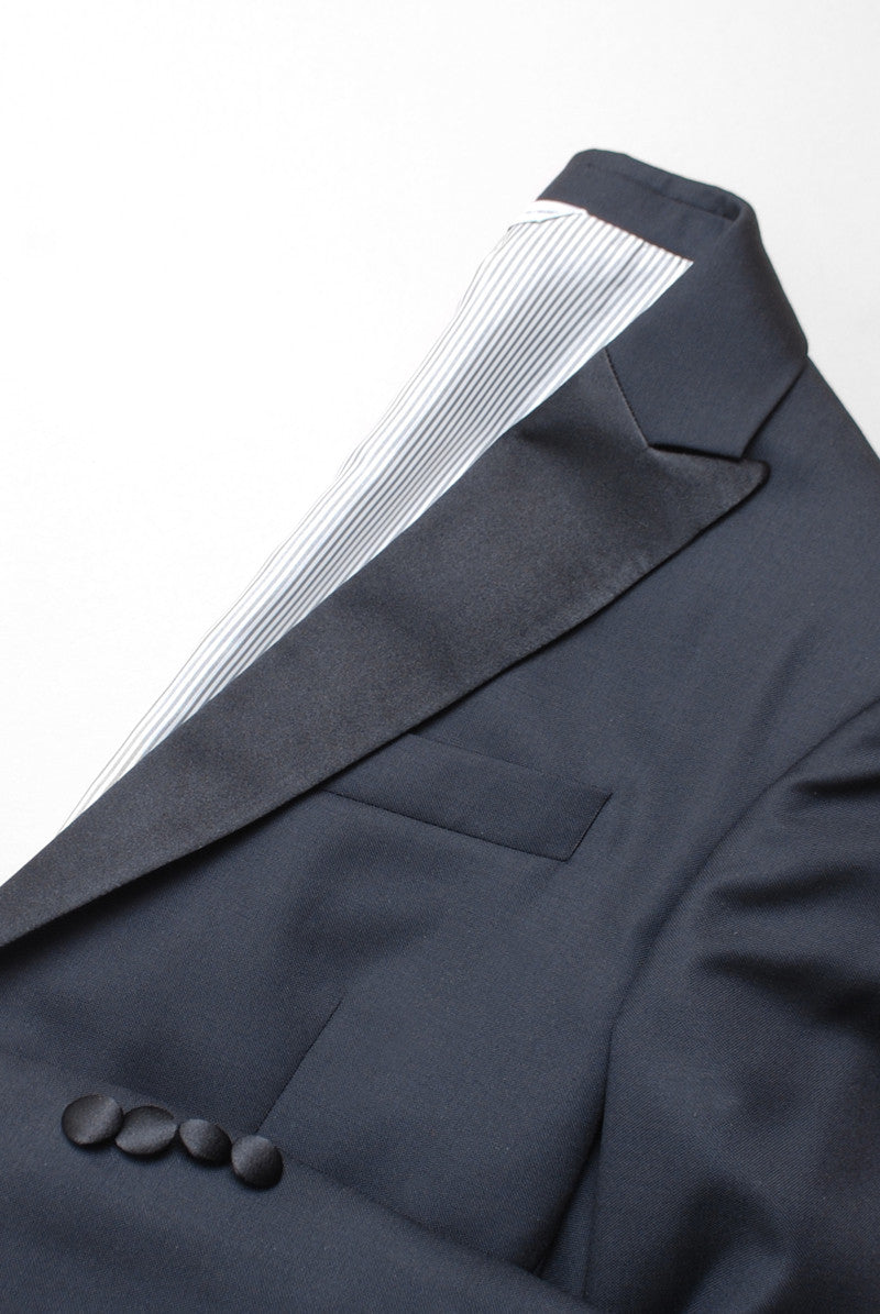 Detail shot of Brooklyn Tailors BKT50 Peak Lapel Tuxedo Jacket in Super 110s - Black with Satin Lapel showing lapel and cuff with contrasting fabrics