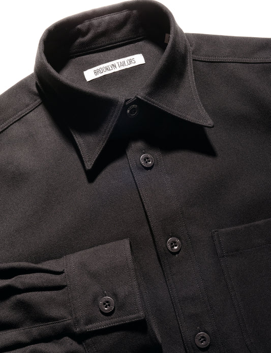 Detail shot of BKT16 Overshirt in Cotton Twill - Black showing buttons, label, and fabric