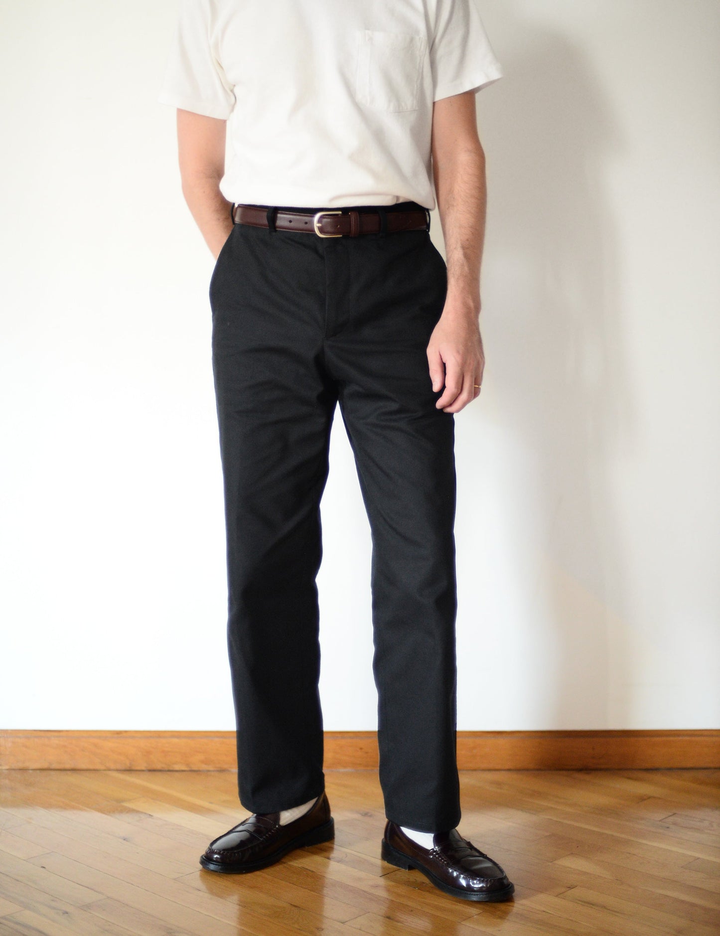 Brooklyn Tailors BKT36 Straight Leg Pant in Cotton Cavalry Twill - Black on-body shot. Model is wearing pants with a white t-shirt, black loafers, and white socks.