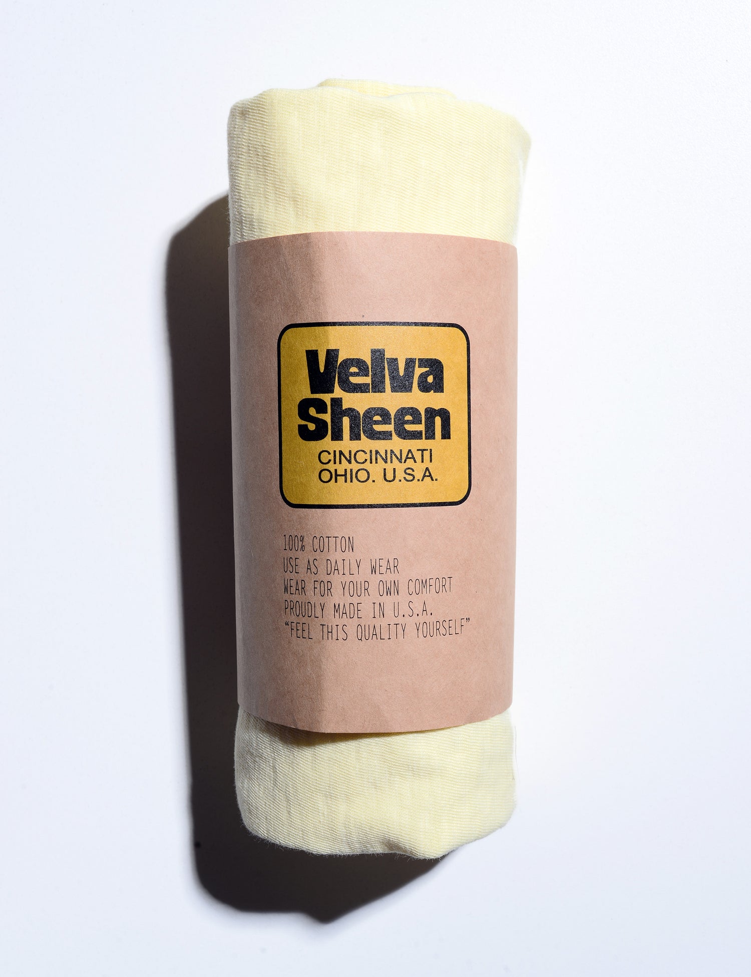 Photo of Velva Sheen Crewneck T-Shirt in Sunshine rolled in its paper packaging