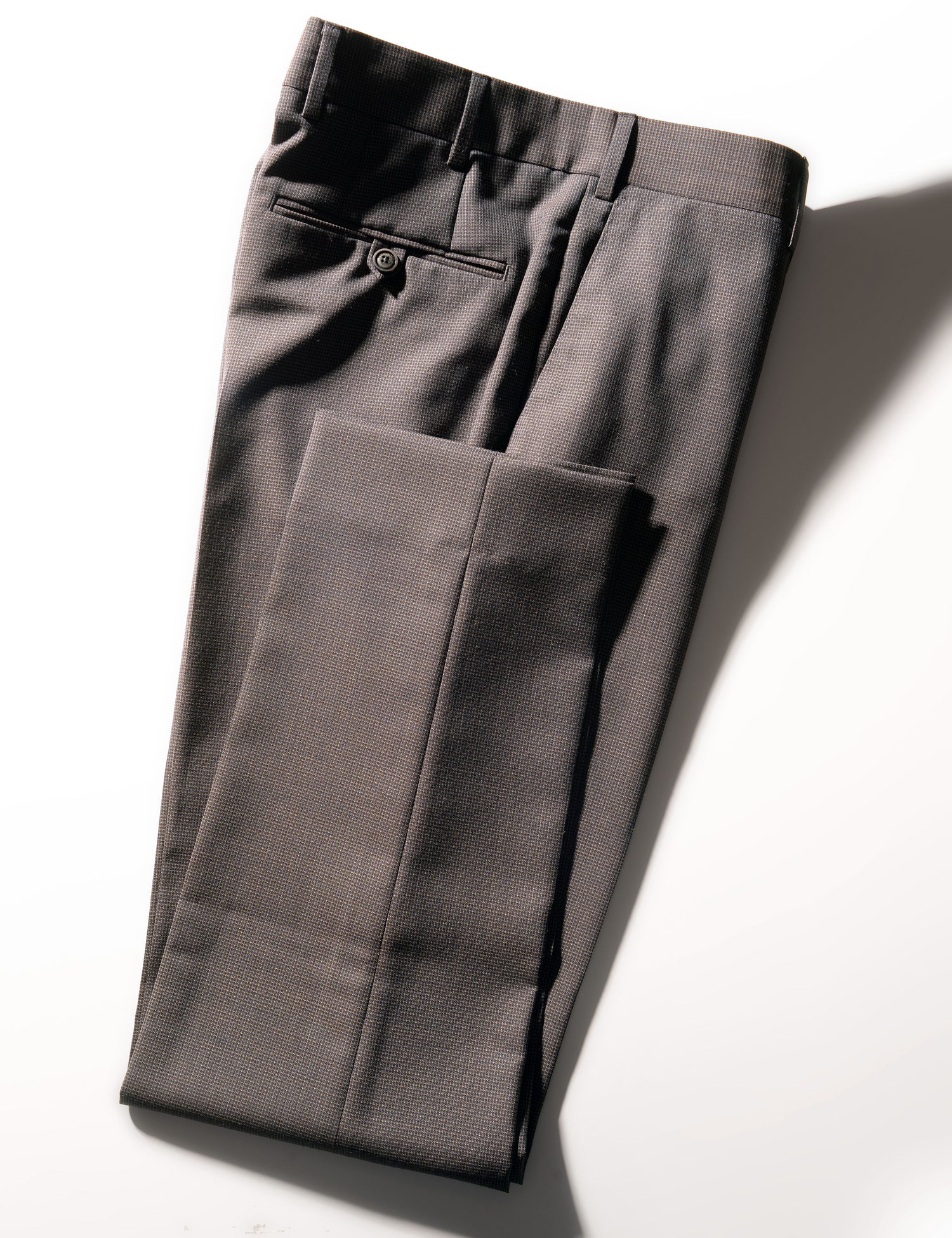 Folded shot of BKT50 Tailored Trousers in Wool Grid Weave - Iron Oxide showing hem, back pocket, and waistband