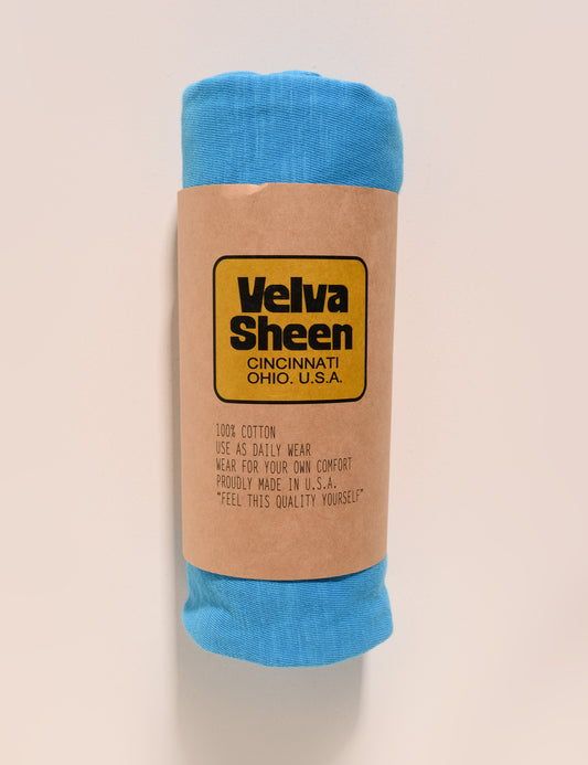 Image of Velva Sheen Crewneck T-Shirt in Adriatic Sea rolled in a paper sleeve