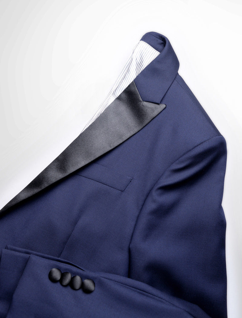 Detail shot of Brooklyn Tailors BKT50 Peak Lapel Tuxedo Jacket in Super 110s - Navy with Satin Lapel showing the lapel, lining, fabric texture, and sleeve cuff with covered buttons