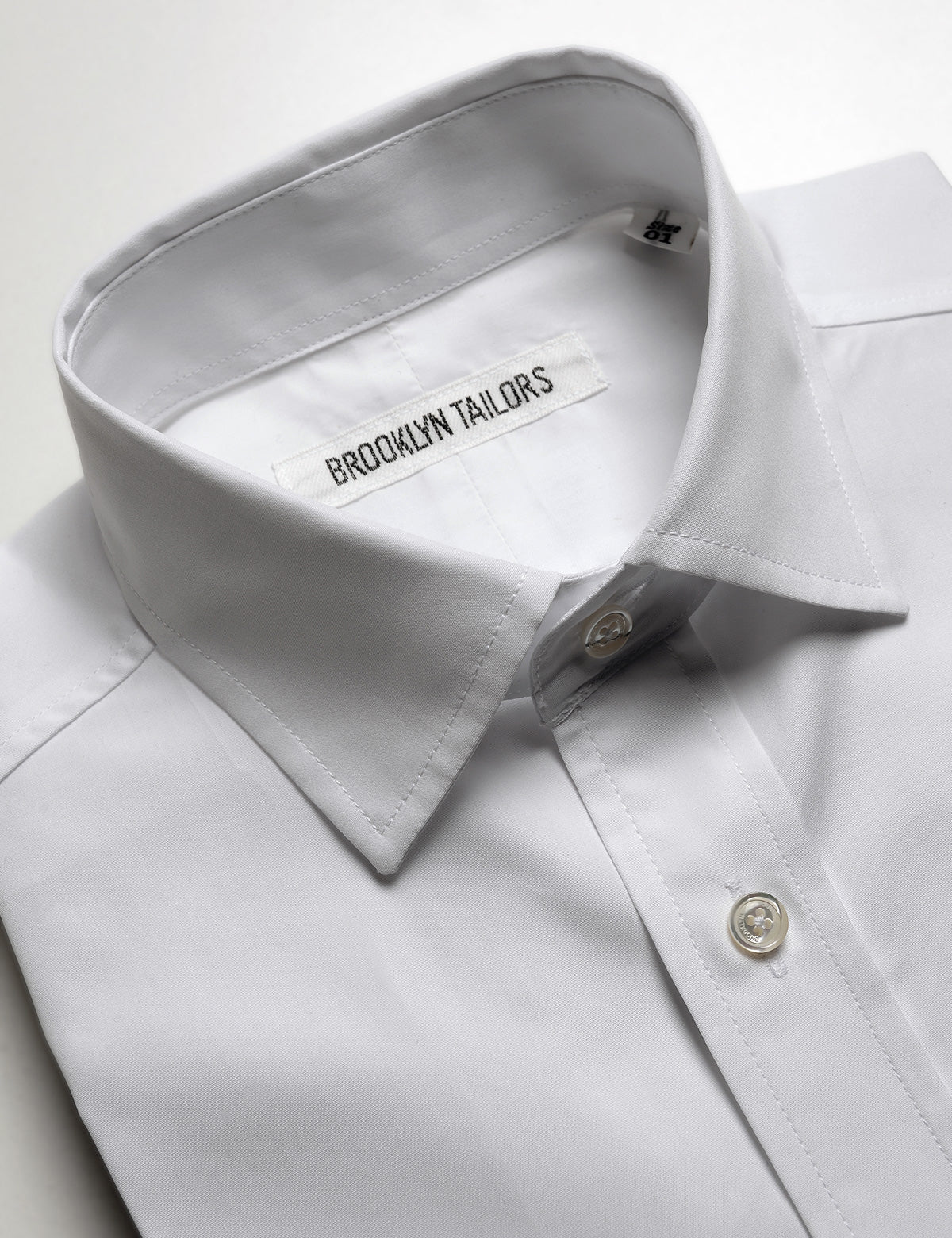 Detail shot showing collar and buttons on Brooklyn Tailors BKT20 Slim Dress Shirt in Crisp Poplin - White