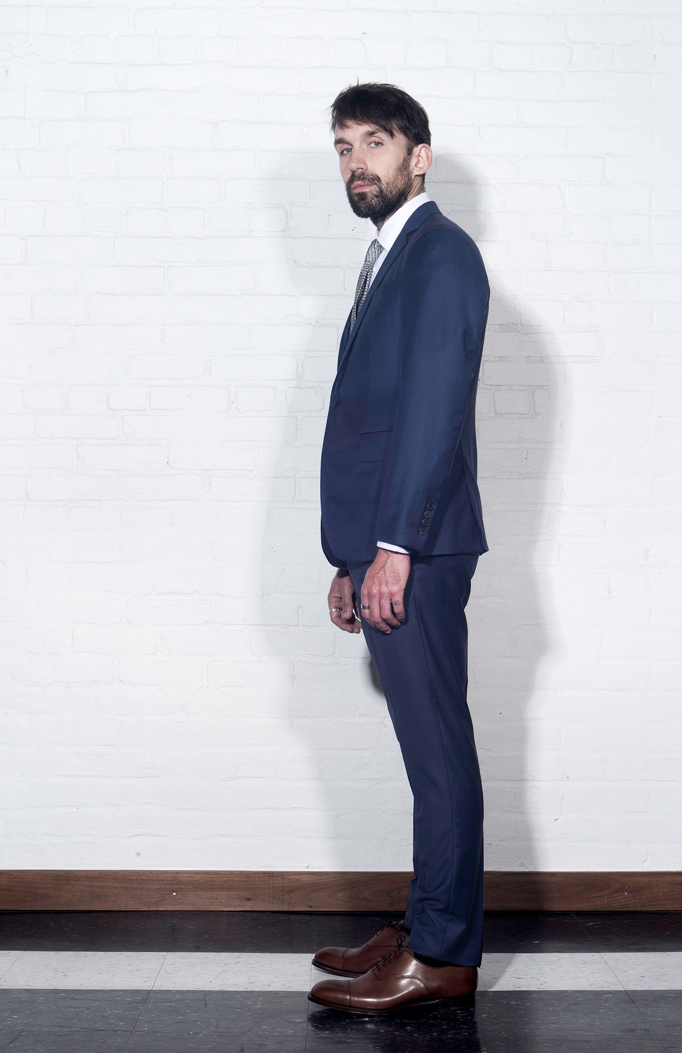 Brooklyn Tailors BKT50 Tailored Trouser in Super 120s Twill - Bright Navy on-body shot. Model is wearing pant with matching jacket, white dress shirt, and tie. Photo taken from the side.