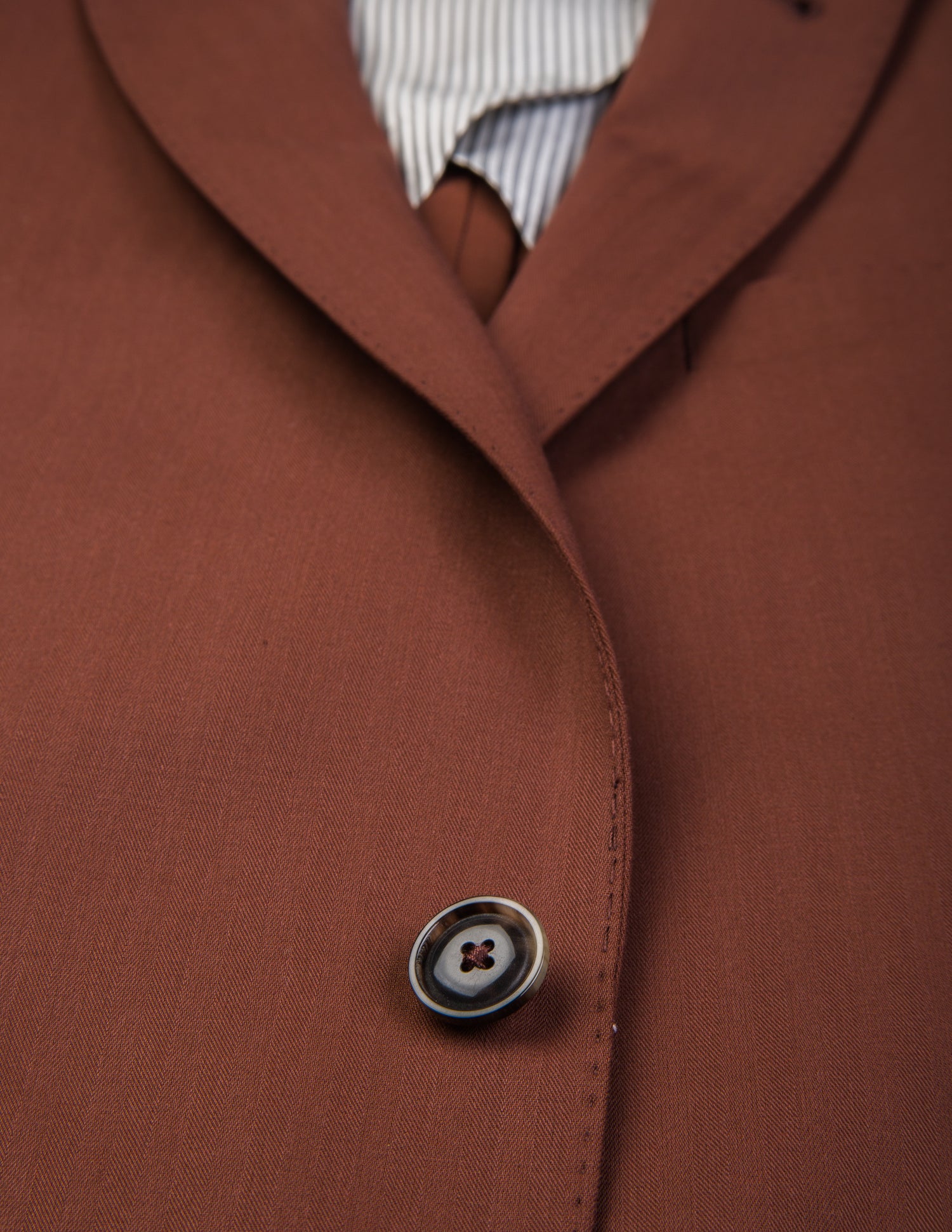 Detail shot of Brooklyn Tailors BKT50 Tailored Jacket in Herringbone Wool/Cotton - Brick showing button and fabric texture
