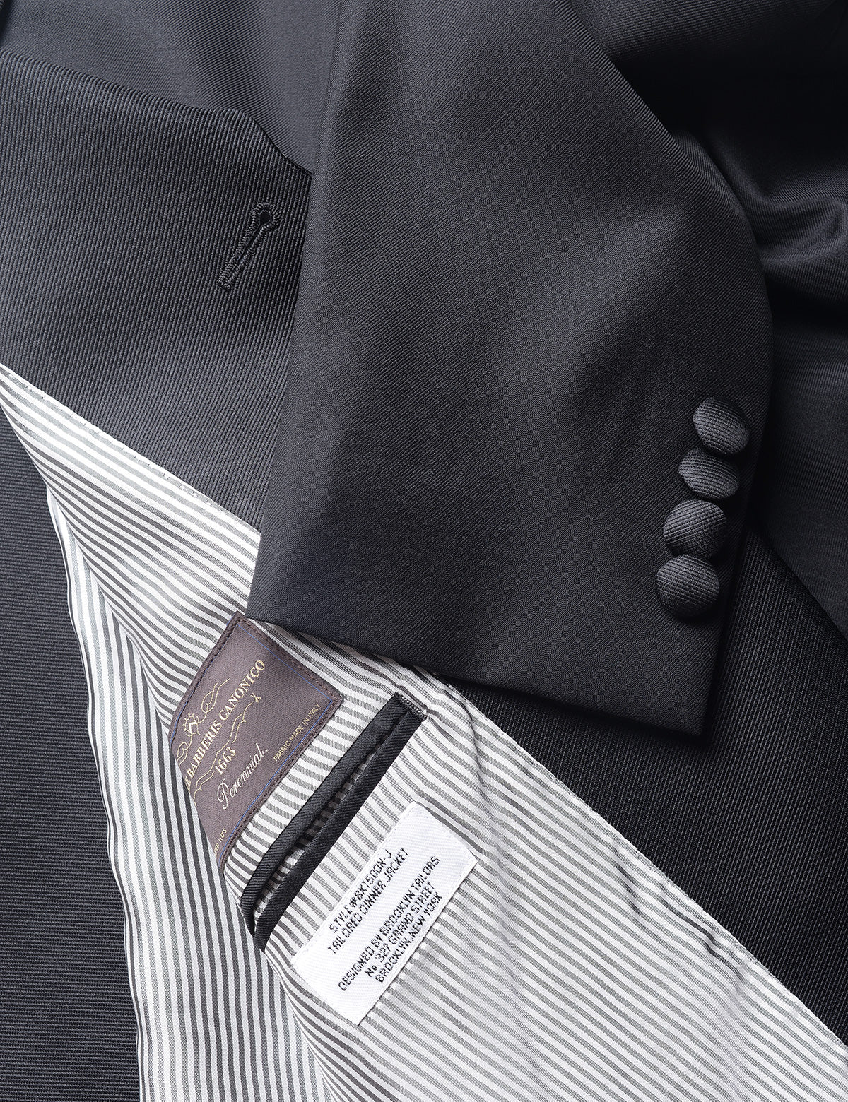 Detail shot of Brooklyn Tailors BKT50 Shawl Collar Tuxedo Jacket in Super 120s Twill - Black with Grosgrain Lapel showing cuff with covered buttons and lining