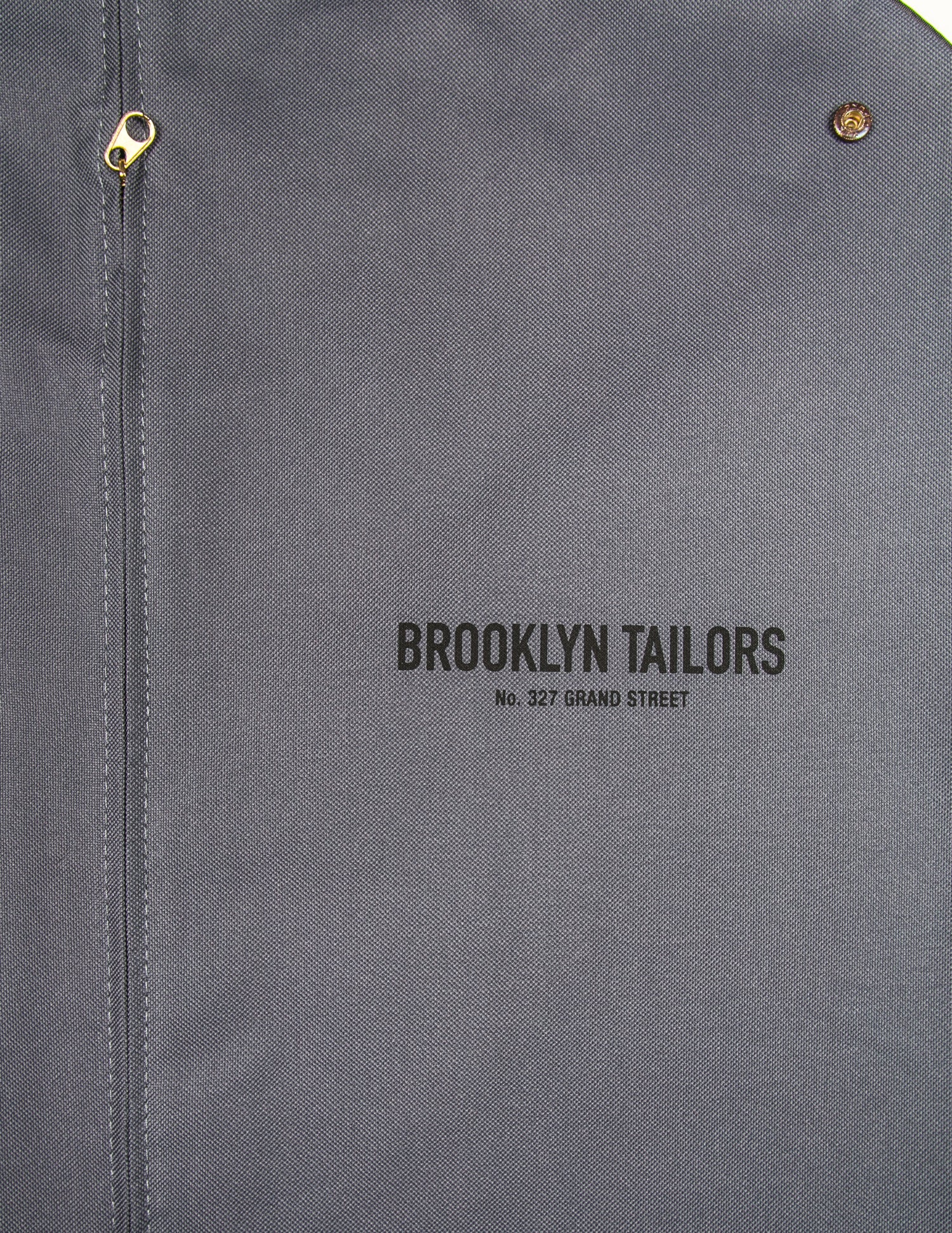 Detail of Brooklyn Tailors BROOKLYN TAILORS - Deluxe Garment Bag showing zipper, snap, and logo