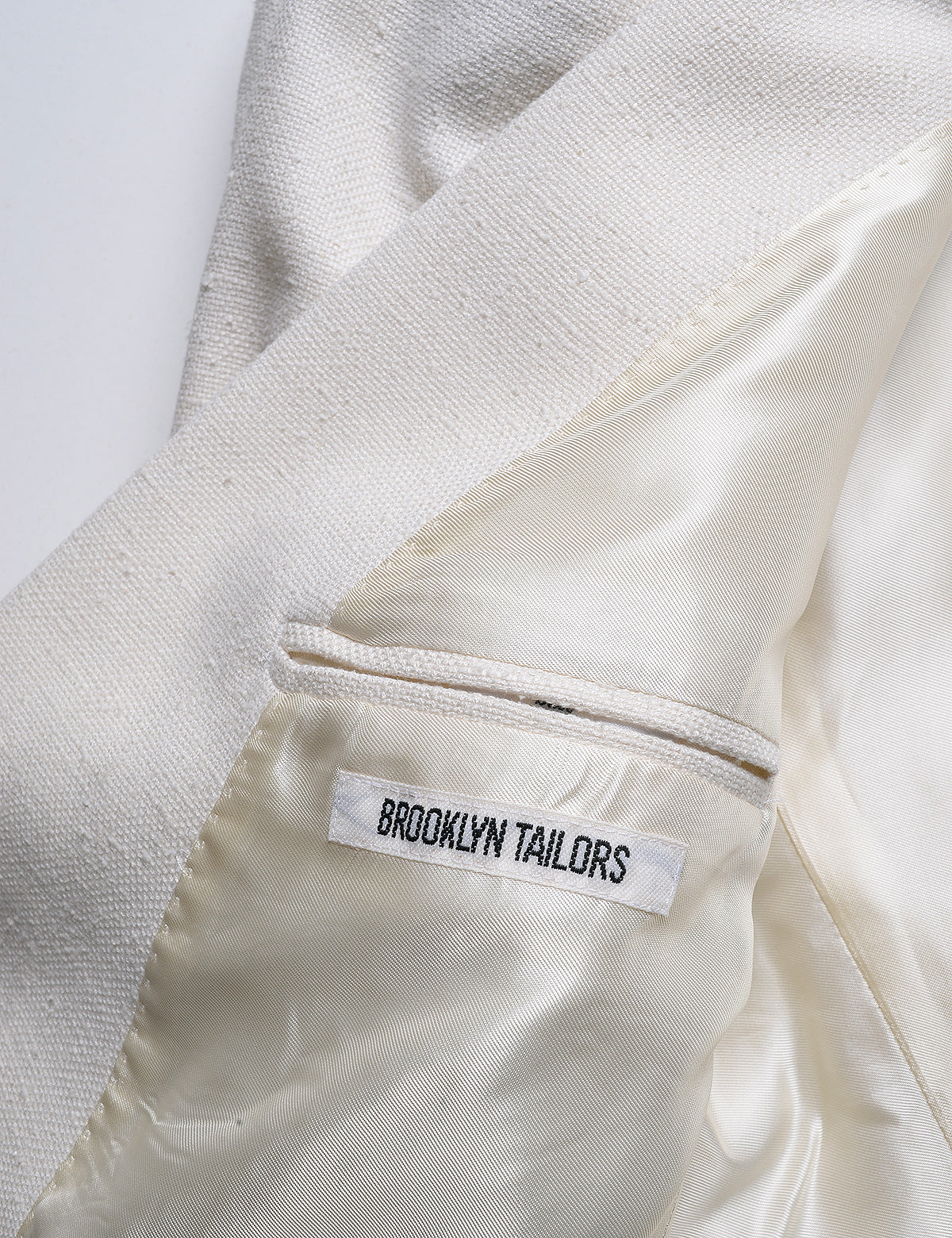 Detail of Brooklyn Tailors BKT50 Shawl Collar Dinner Jacket in Silk & Wool Hopsack - Ivory showing Brooklyn Tailors label on the interior of the jacket