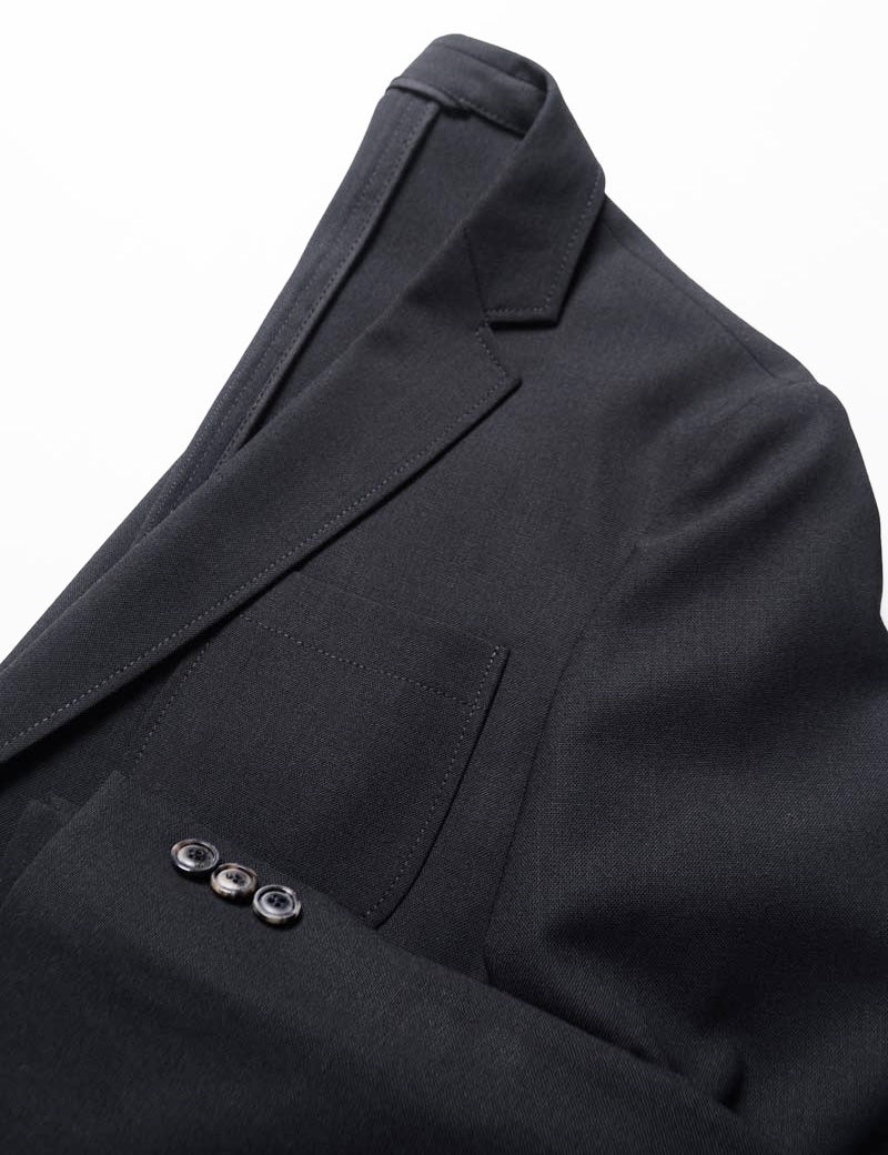 Detail of BKT35 Unstructured Jacket in Travel-Ready Wool - Black (Prototype Version) showing lapel, chest pocket, and cuff