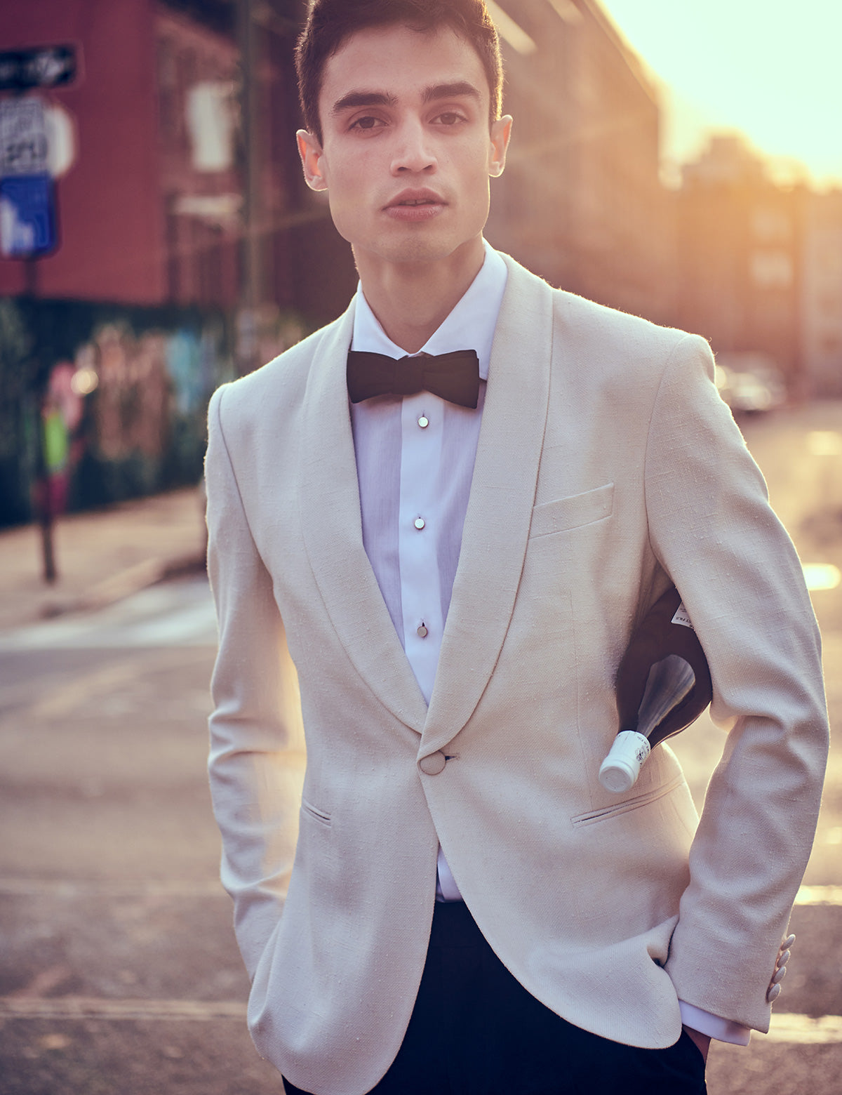 Photo of Brooklyn Tailors Formal Bowtie in Black Satin on model wearing cream dinner jacket and white tux shirt