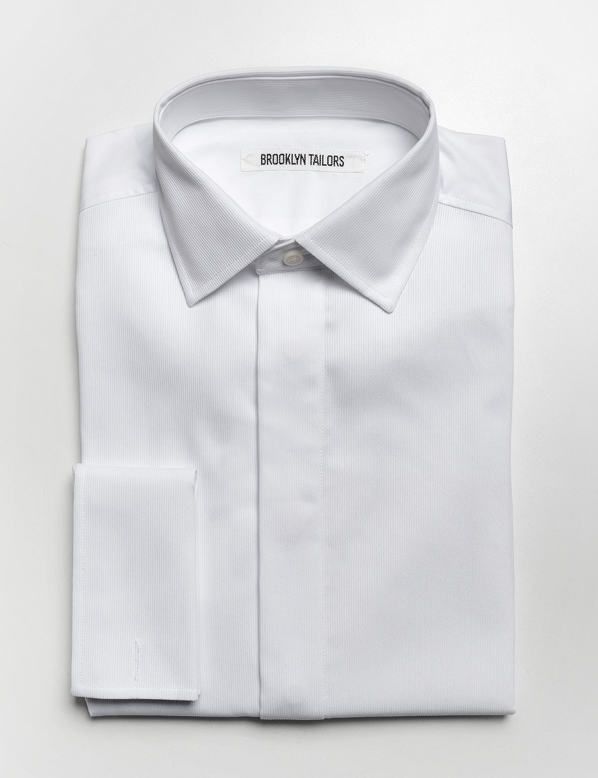 Folded flat shot of Brooklyn Tailors French Cuff Tuxedo Shirt With Covered Buttons - Bar Pique