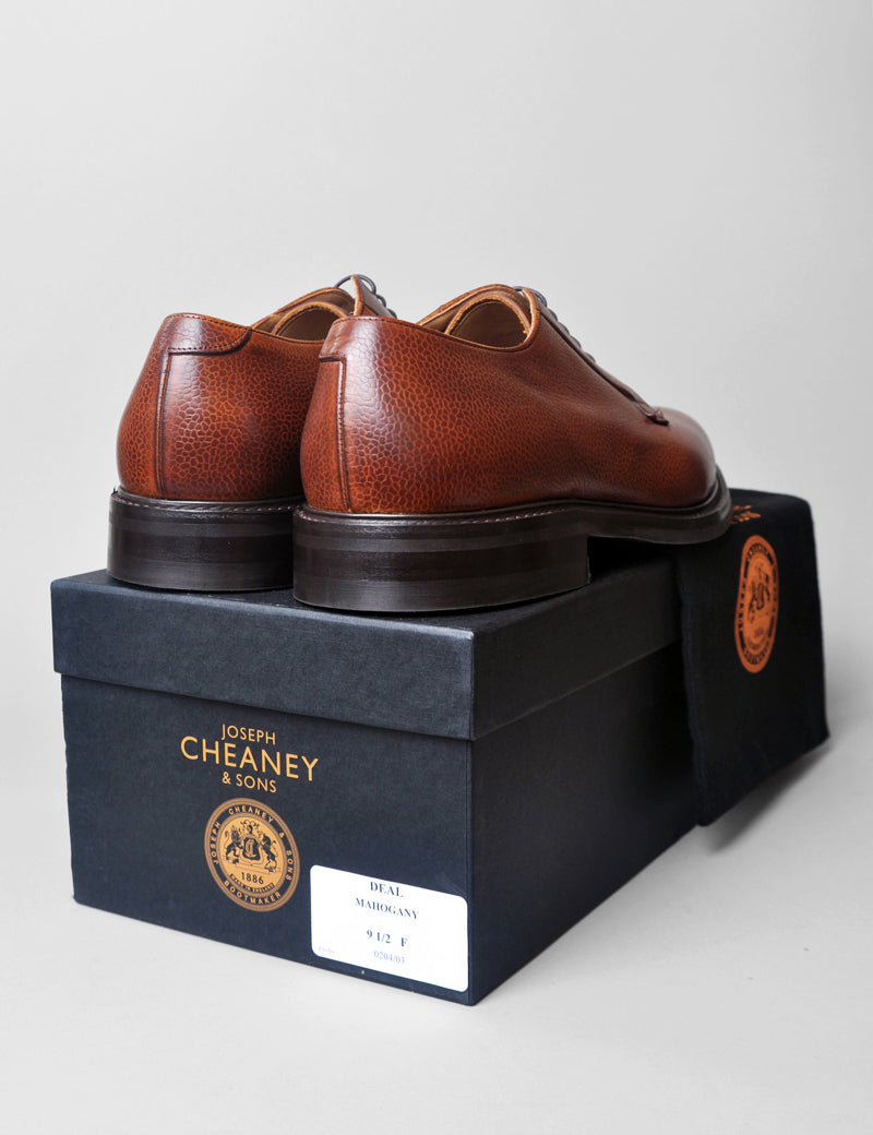Photo of Joseph Cheaney Deal II Derby in Mahogany Grain Leather from the back sitting on the box they are sold in with the dust bag they come in