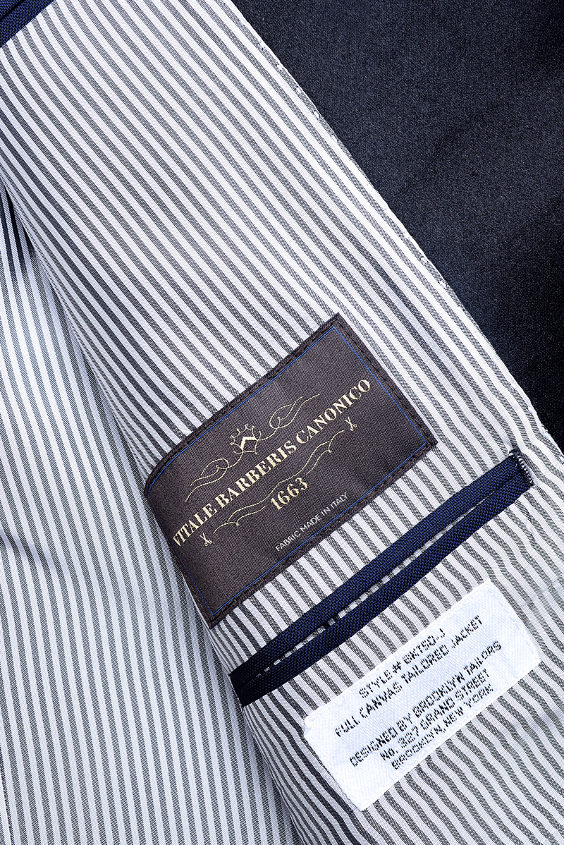 Detail shot of Brooklyn Tailors BKT50 Peak Lapel Tuxedo Jacket in Super 110s - Navy with Satin Lapel showing the Vitale Barberis Canonico label on the interior. 